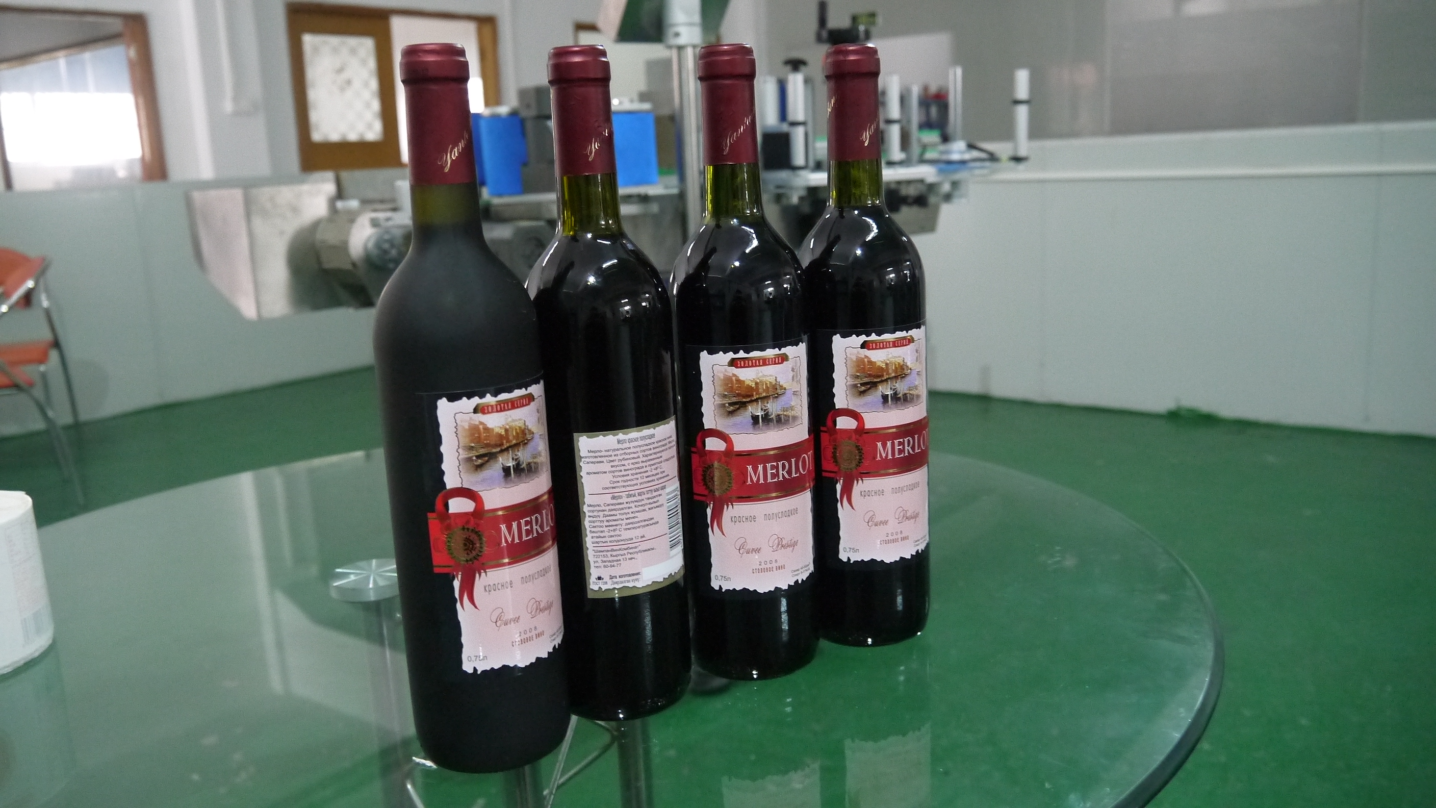 半自动卧式圆瓶贴标机应用于红酒瓶贴标